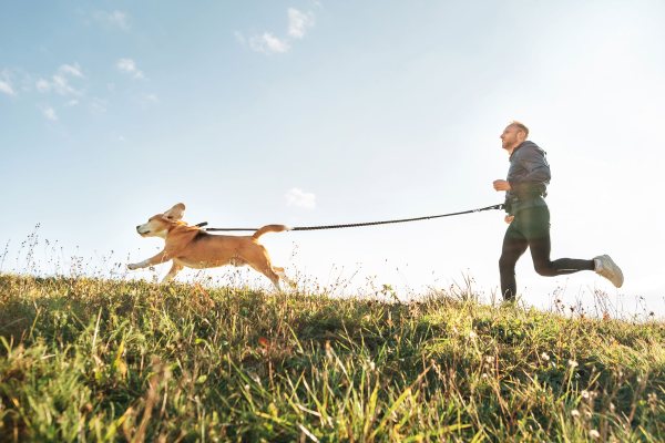 man running with dog on a leash