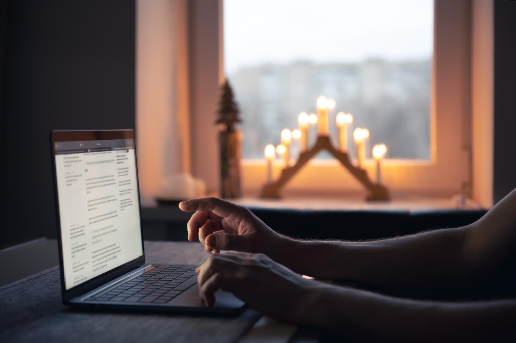 Person using a laptop by candlelight.