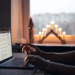 Person using a laptop by candlelight.