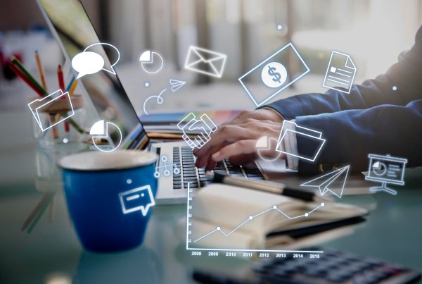 Person working on a laptop with digital marketing icons.