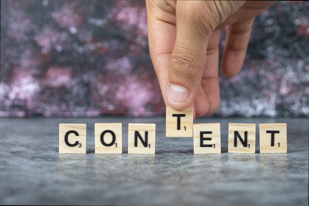 spelling out CONTENT in wooden letter blocks with black text
